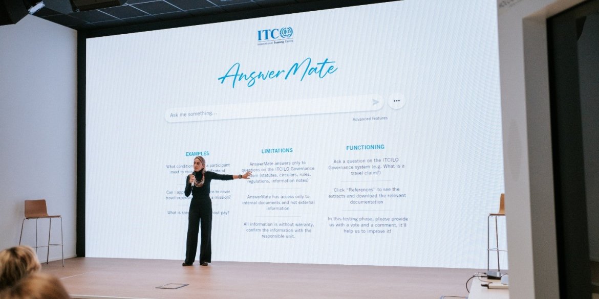 woman standing in front of large screen displaying information about ITCILO chatbot