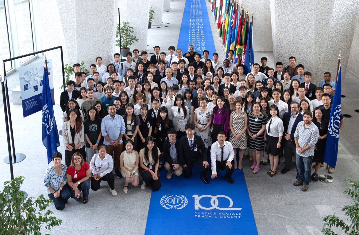 "Future Leaders in the World of Work — South-South University" participants, staff and lecturers pose with the flags of the 187 ILO member states on display at the ILO headquarters, Geneva.