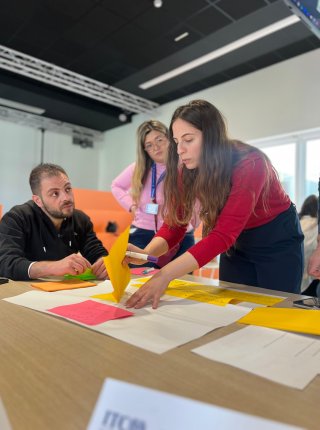 three group members discussing their proposal